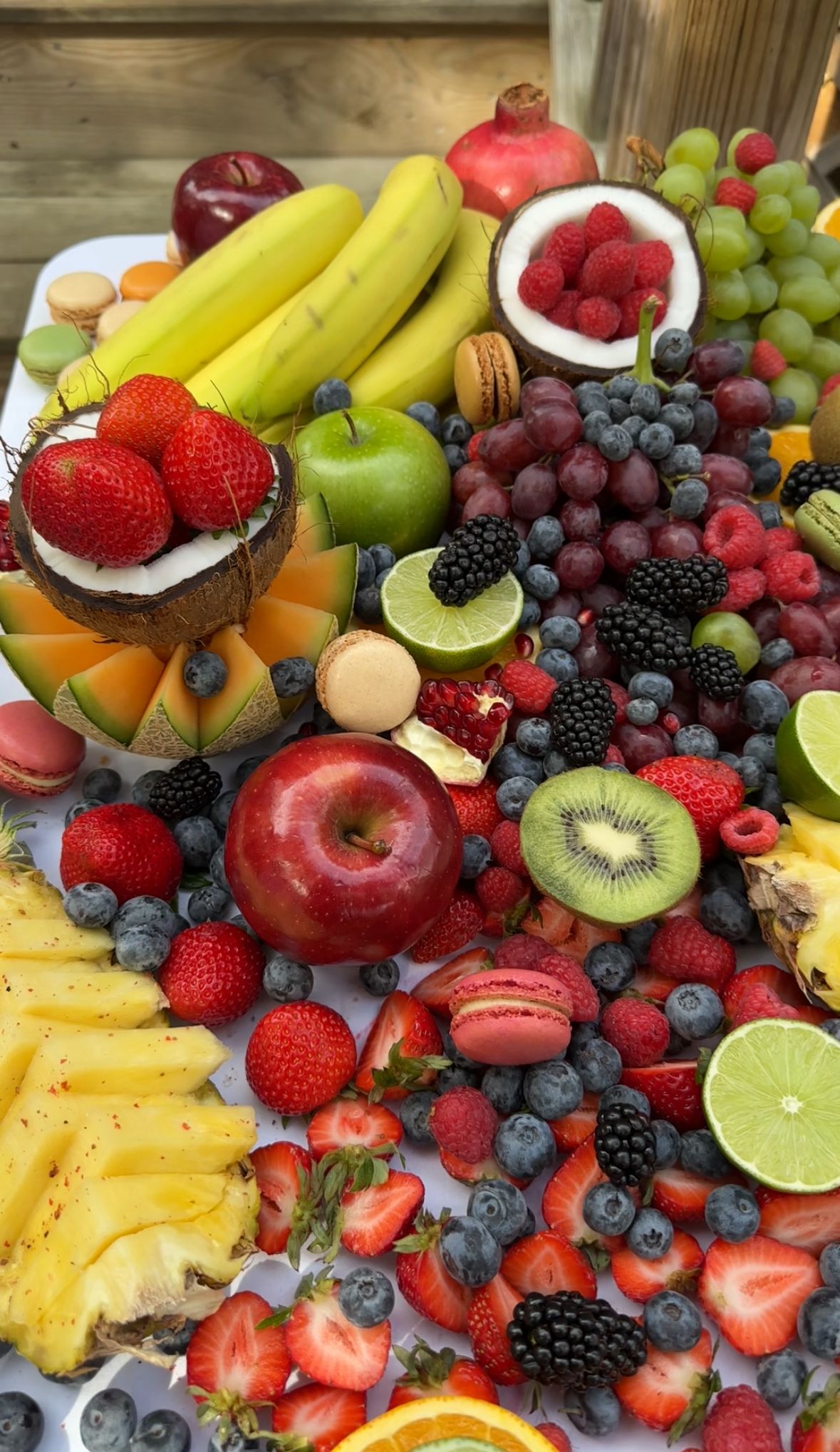 Colorful fruit display with berries and macarons
